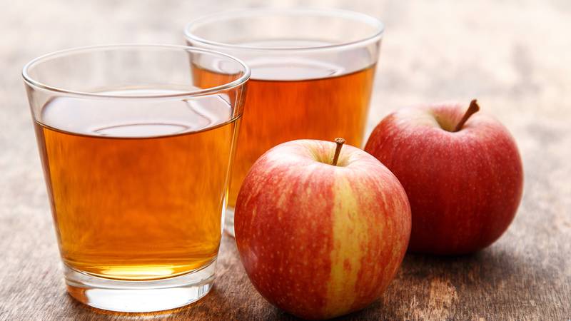 Glasses of apple juice and apples on a table